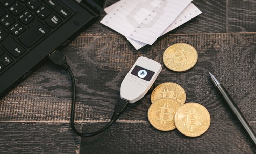 仮想通貨を保管するハードウェアウォレットTREZORと金色のビットコイン