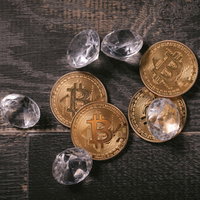 採掘したダイヤとビットコイン、木製テーブルに置かれた資産の写真