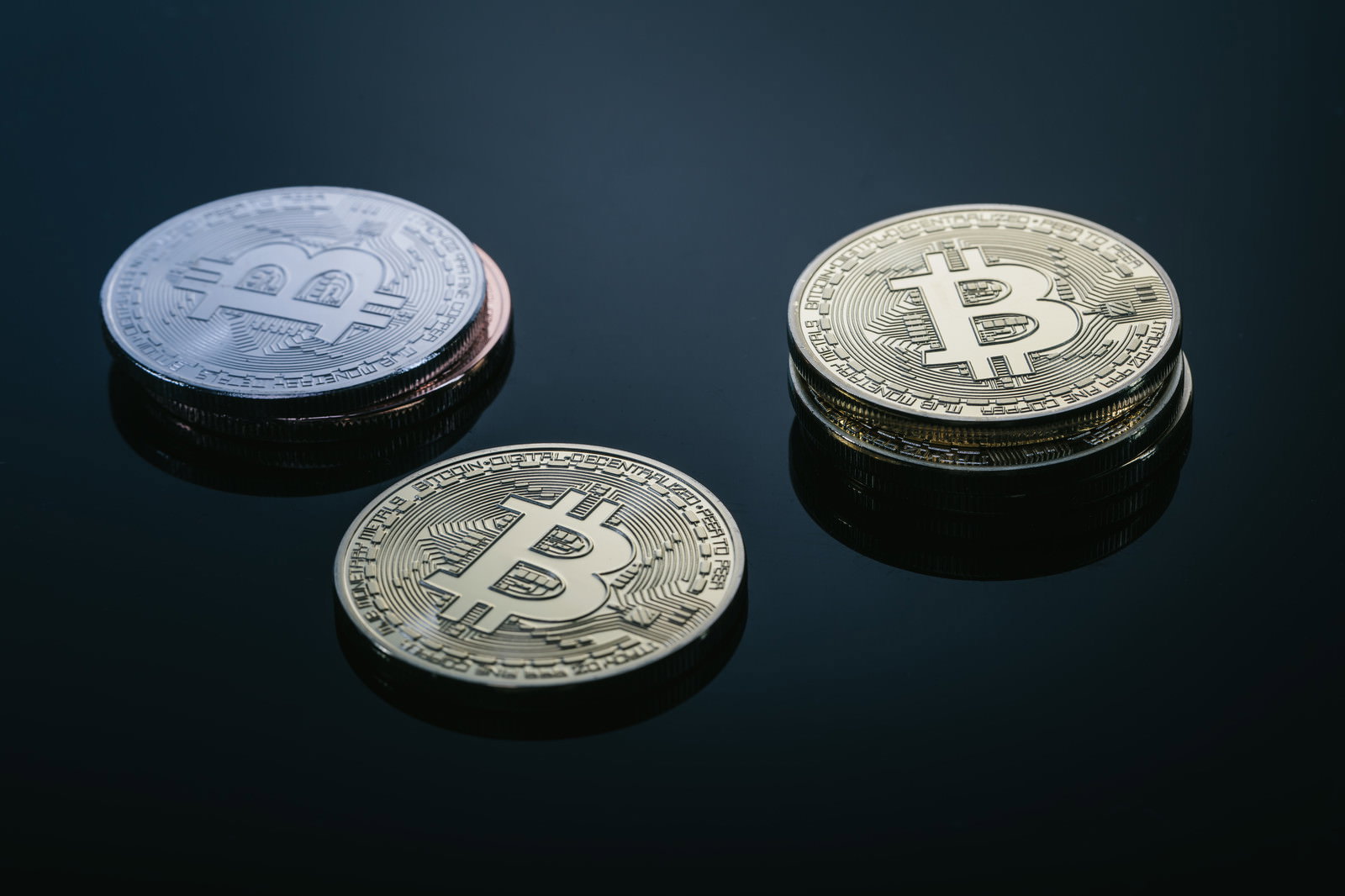 青緑色の背景に並んだビットコインのコイン