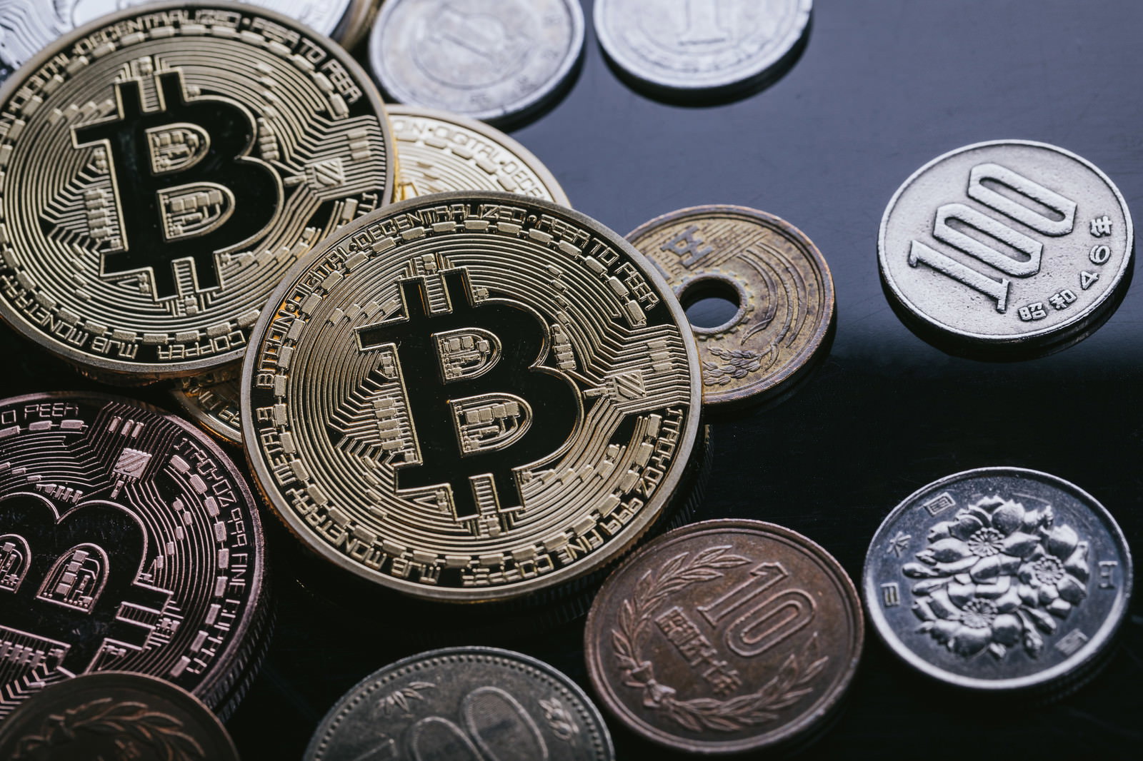 ビットコインコインと日本円硬貨が並んだ写真