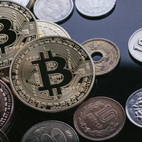 ビットコインと日本円の硬貨を並べた仮想通貨と法定通貨の取引の写真