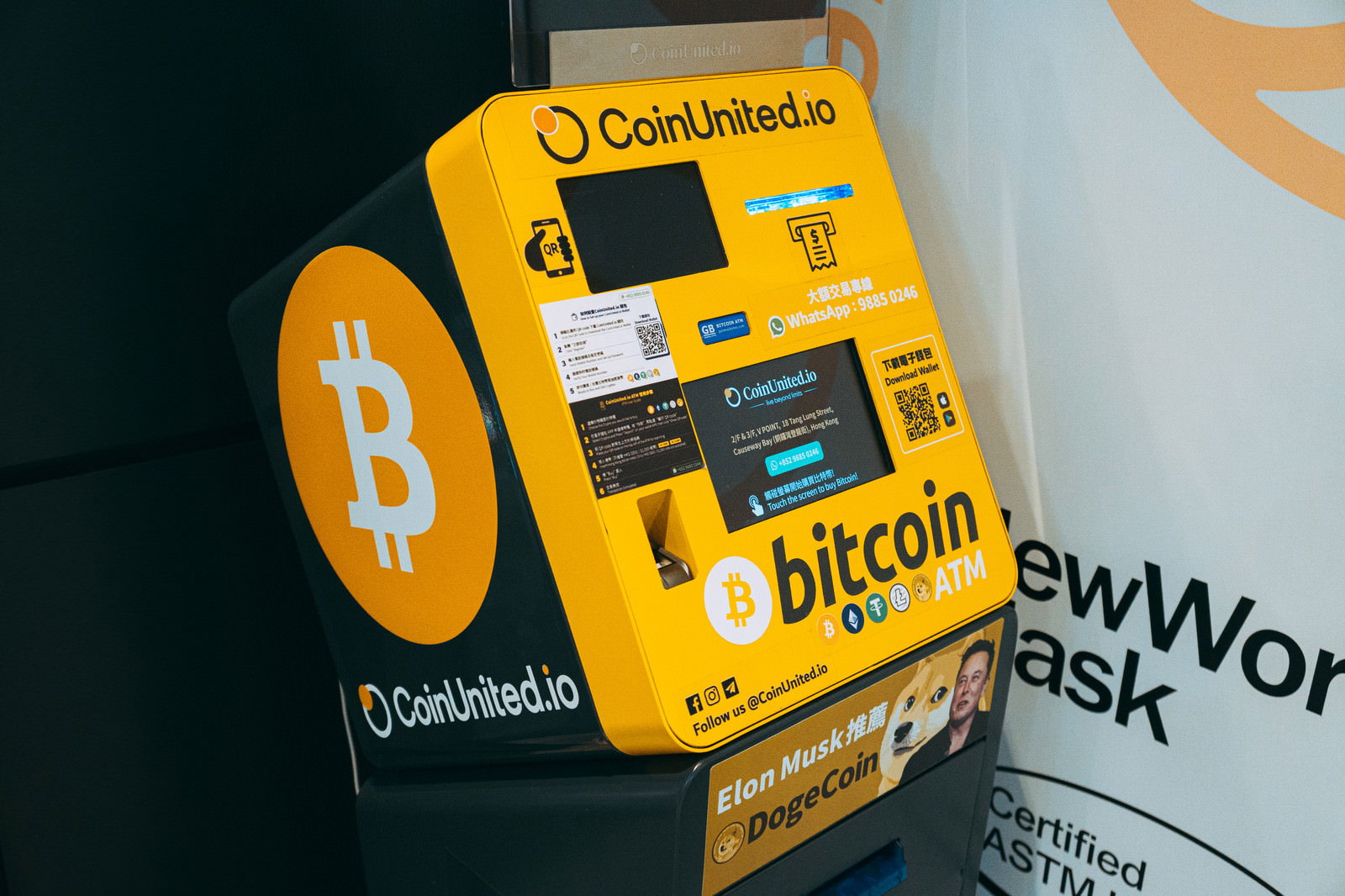 黄色いビットコインATMの操作画面とロゴが表示された自動預け払い機