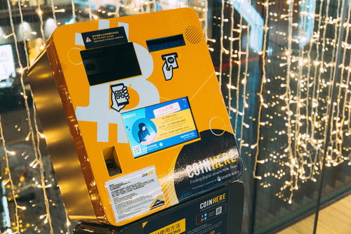 金色の電飾が光るオレンジ色のbitcoinATM