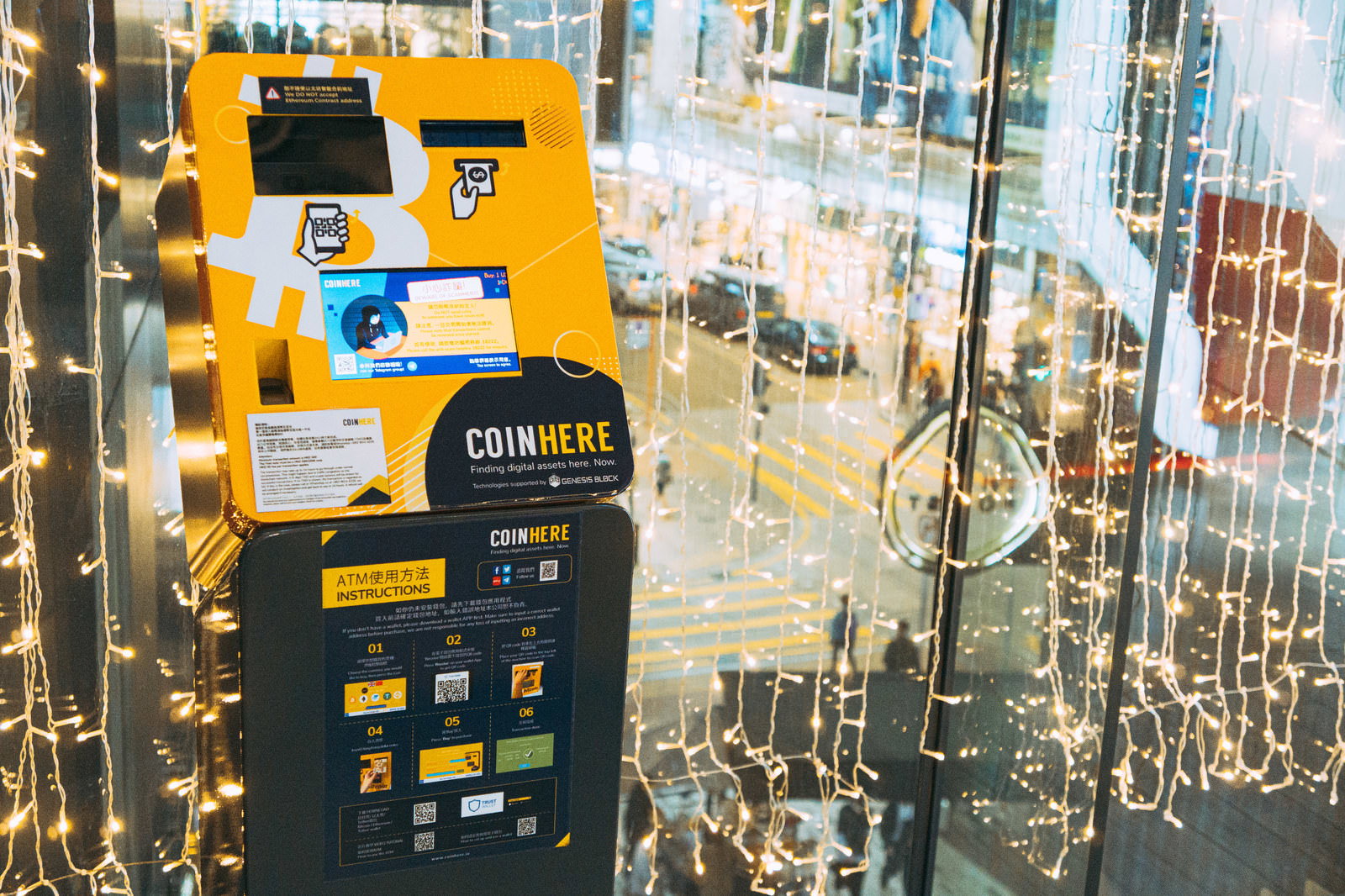 夜の街角で電飾に照らされる黄色いbitcoinATM機