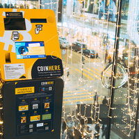 夜の街角で灯る電飾とbitcoinATMの写真