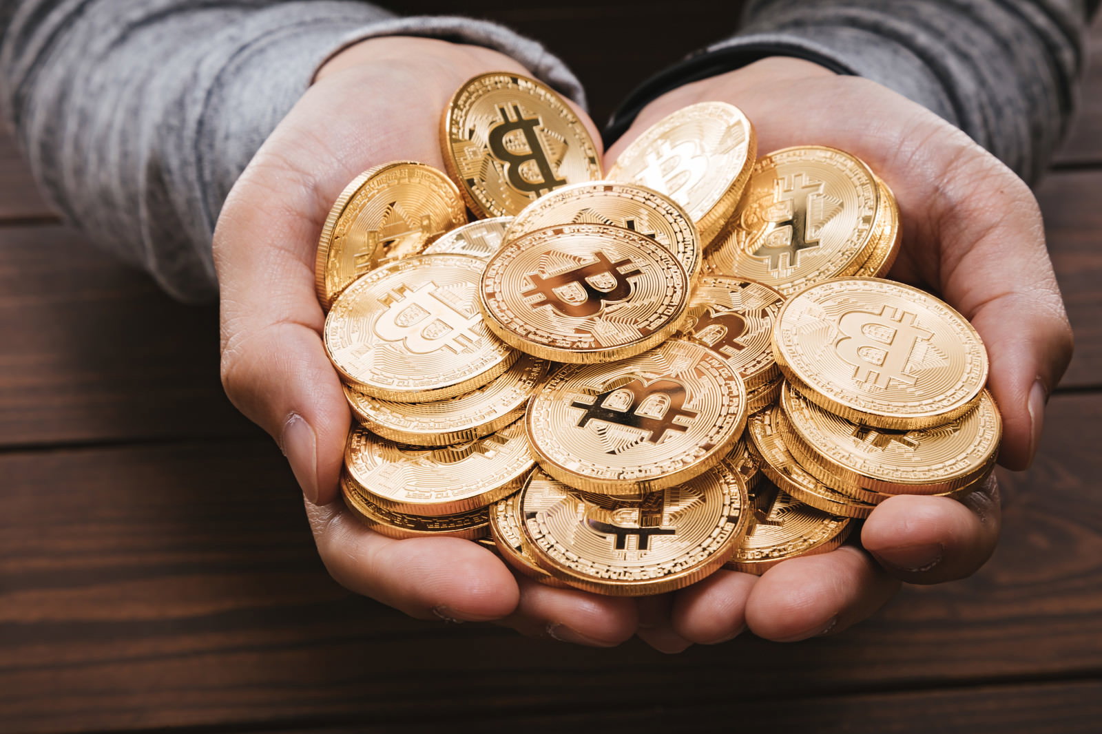 両手いっぱいにビットコインの金貨を持っている様子