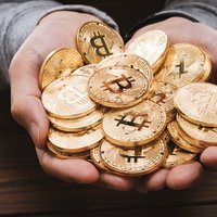 両手いっぱいにHOLDした金色のビットコインの写真