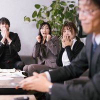 上司の巻取り方に驚く会社員の部下達、会議室での対応の写真