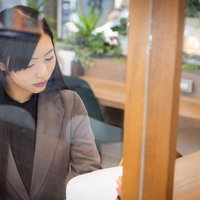 コワーキングスペースで書類を確認する女性社員の写真