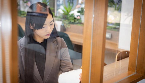 コワーキングスペースで書類を確認する女性社員