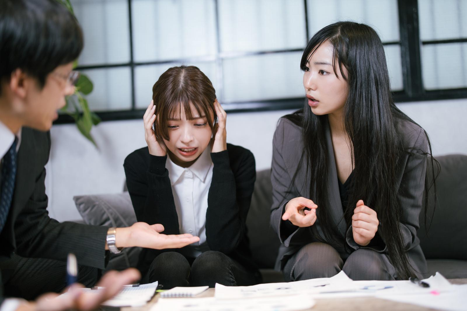 提案資料を前に頭を抱える女性社員［モデル：なんこ 高尾実生］