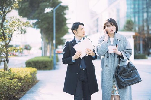 アポ無しで営業電話をかける女性の上司と不安そうな顔で見つめる外回りの男性社員