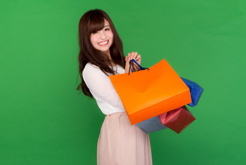 ブラックフライデーの大規模な安売りで両手いっぱいに買い物袋を抱える女性