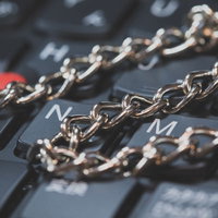 キーボードの上を横切るゴールドチェーン、デジタルセキュリティの写真