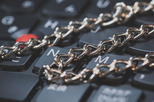 キーボードの上を横切るゴールドチェーン、デジタルセキュリティ