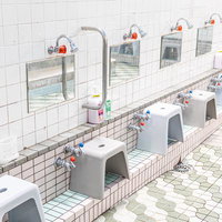 銭湯の洗い場に並ぶ蛇口と風呂椅子の写真