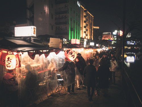 福岡屋台の夜の人混みと賑わい、ラーメン屋台での夜間営業風景