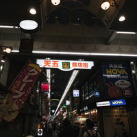 商店街入り口の大きな看板と行き交う人たちの写真