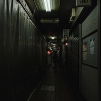 薄暗い路地裏に佇む閉店間際の居酒屋の夜間風景の写真