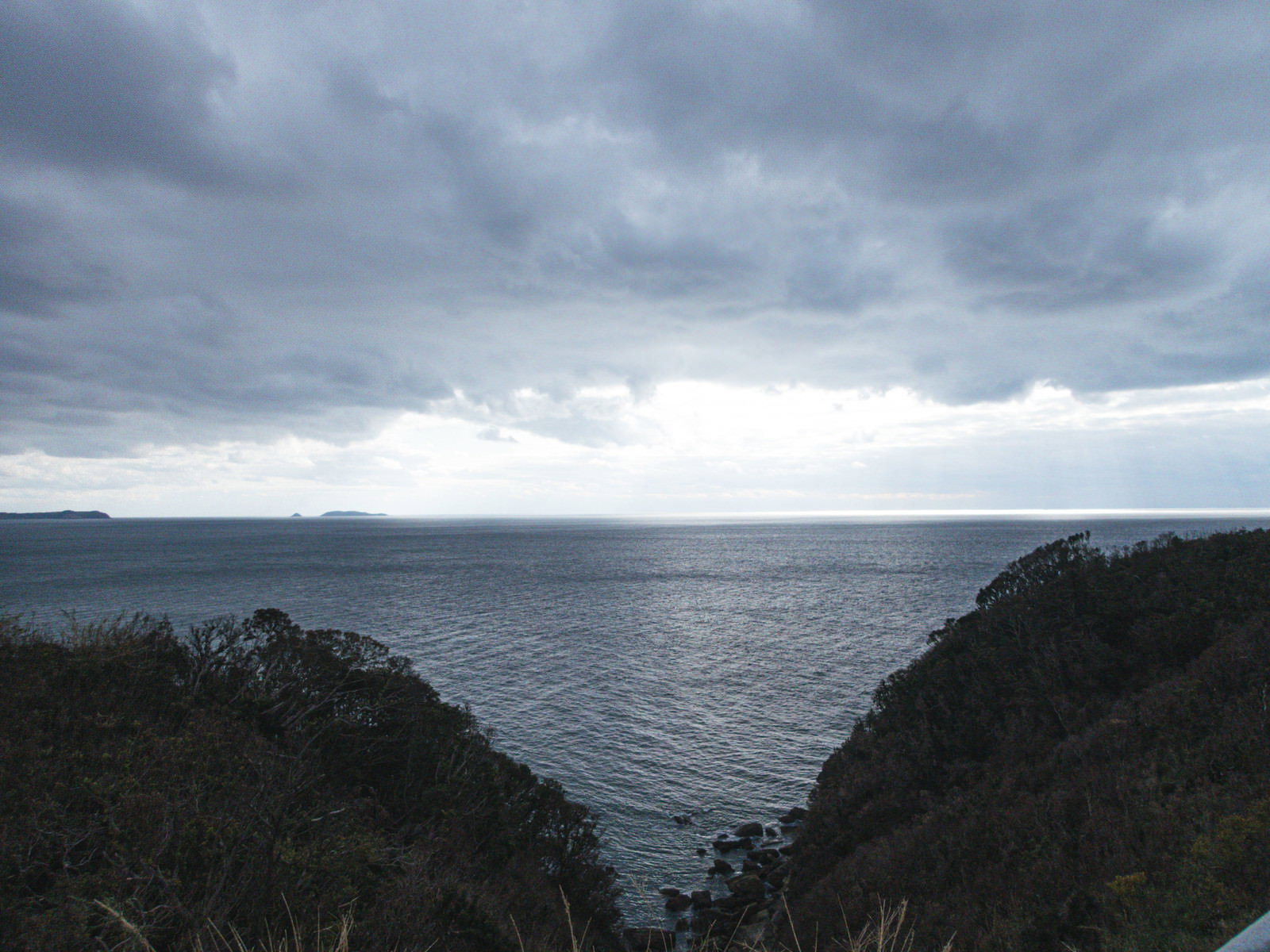 曇り空の下に広がる海岸線と崖に囲まれた海の風景