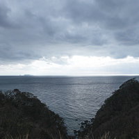 曇り空の下に広がる海岸線と崖の自然風景の写真