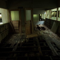 床が崩れ落ちそうな廃墟の室内、腐食した床板と損傷した壁の写真