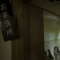 お手洗い所と書かれた廃墟のトイレの入り口の写真