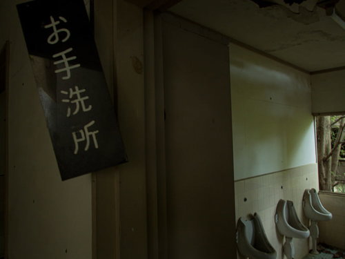 お手洗い所と書かれた廃墟のトイレの入り口