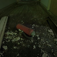 おそらく使えない廃墟に転がる赤い消化器と瓦礫の写真