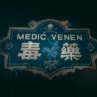 独特なフォントで書かれた毒薬の文字と緑色のエンブレムの写真