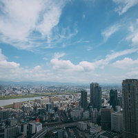 淀川が流れる大阪梅田の街並みと青空、高層ビル群の写真