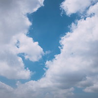 雲の隙間から覗く青空と白い雲が浮かぶ快晴の風景の写真