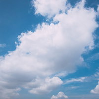 青空にもわっとした白い雲が浮かぶ晴れた日の空の写真