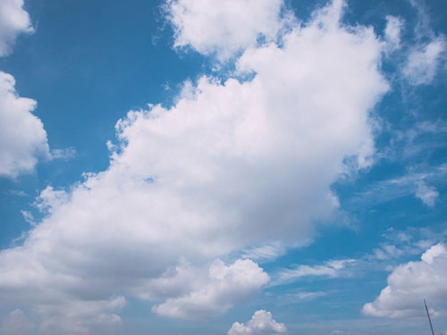 青空にもわっとした白い雲が浮かぶ晴れた日の空