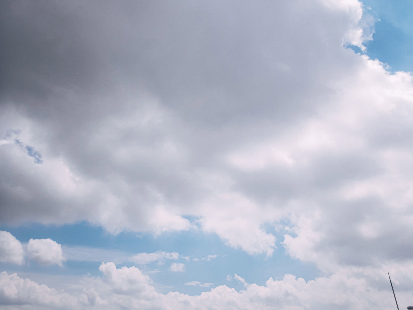 青空に浮かぶ白と灰色のグラデーションが美しい雲の写真