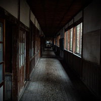 不気味に続く廃校の廊下 - 古い木造校舎の薄暗い奥行きの写真