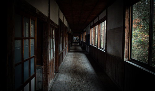 不気味に続く廃校の廊下 - 古い木造校舎の薄暗い奥行き