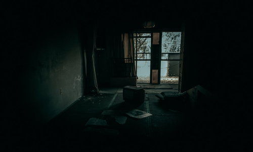 薄暗い和室に置かれた古いテレビ、廃屋の不気味な空間