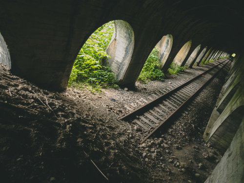 石積みアーチが一部崩落した廃線トンネルの線路跡