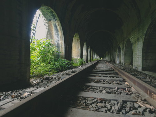 どこまでも続く石造りアーチのトンネルと廃線の線路