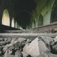 廃線のトンネルとバラストの石の写真