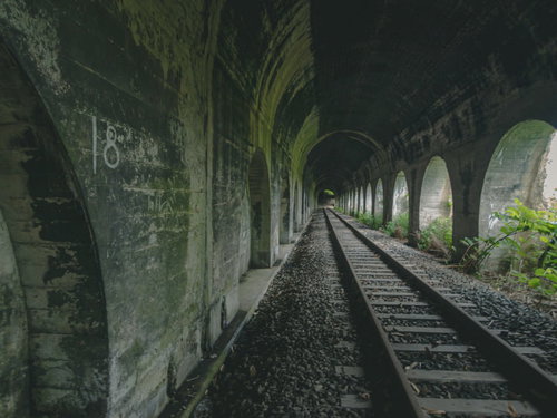 石積みアーチが連続する廃線のトンネルと線路
