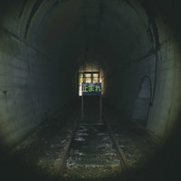 廃線のトンネル奥にある「止まれ」の看板の写真