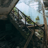 瓦礫で埋まった廃墟の階段と破損した手すりの写真