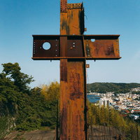 錆び付いた十字の鉄骨構造と青空のコントラストの写真