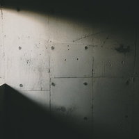 コンクリート壁に差し込む日の光と影 窓から差し込む自然光の写真