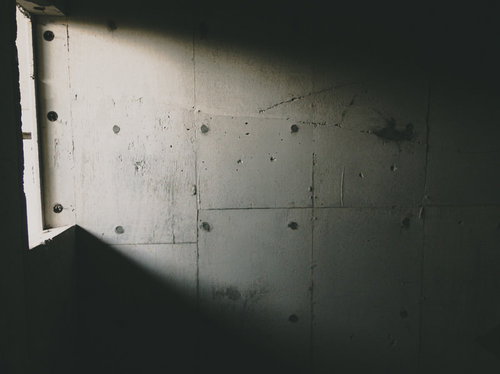 コンクリート壁に差し込む日の光と影 窓から差し込む自然光