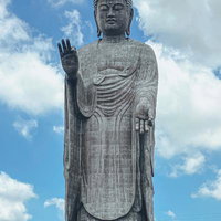 青空に聳える巨大な牛久大仏の立像の写真