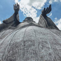 青空に向かって両手を挙げる牛久大仏の姿の写真
