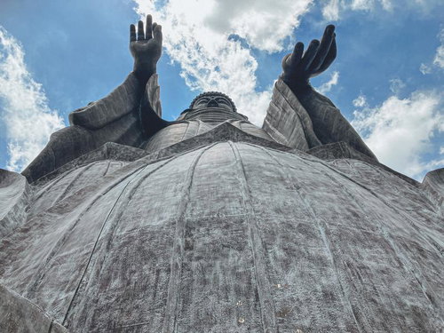 青空に向かって両手を挙げる牛久大仏の姿